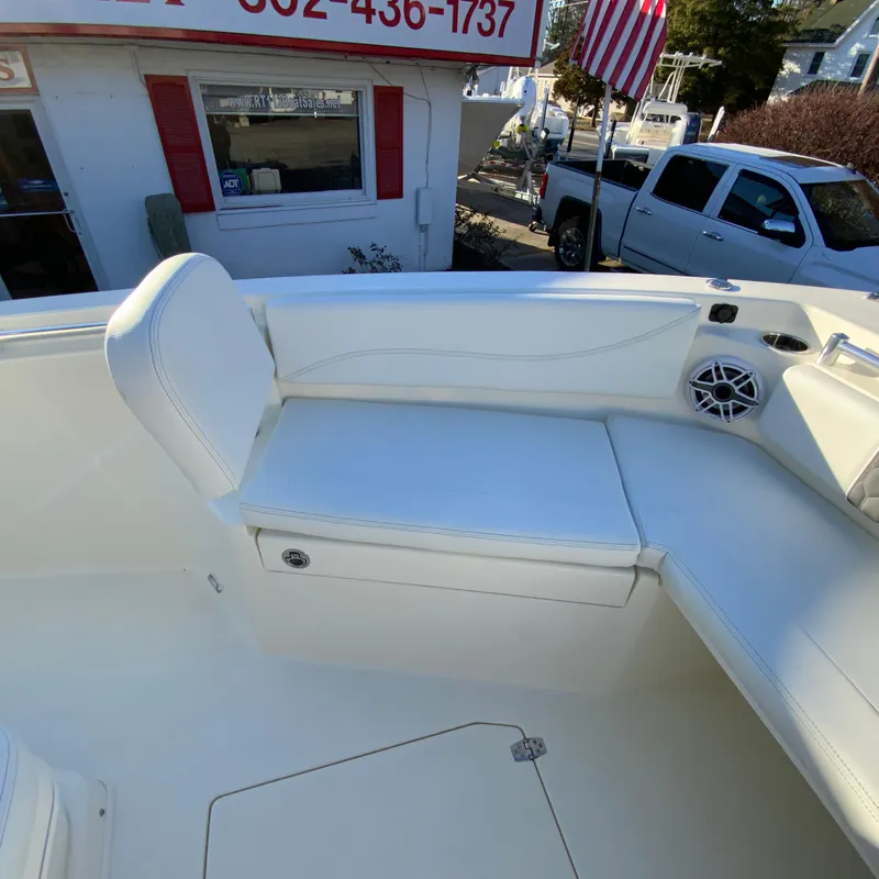 Slide: The Image of 2025 Cobia 240 Center Console boat interior with white seating and speaker. - 23