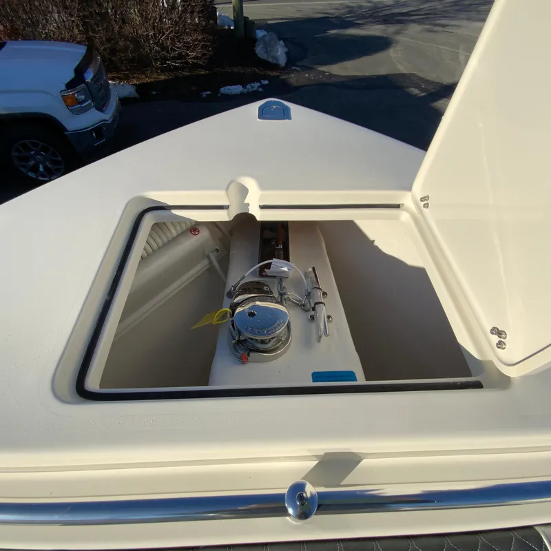 Slide: The Image of Open hatch on 2025 Cobia 240 Center Console boat, revealing interior equipment. - 25