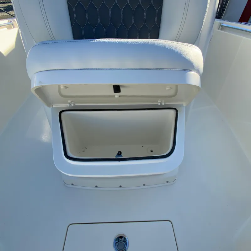 Slide: The Image of 2025 Cobia 240 Center Console seat with open storage compartment. - 28