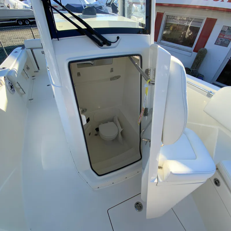 Slide: The Image of 2025 Cobia 240 Center Console boat with open cabin door revealing interior. - 29