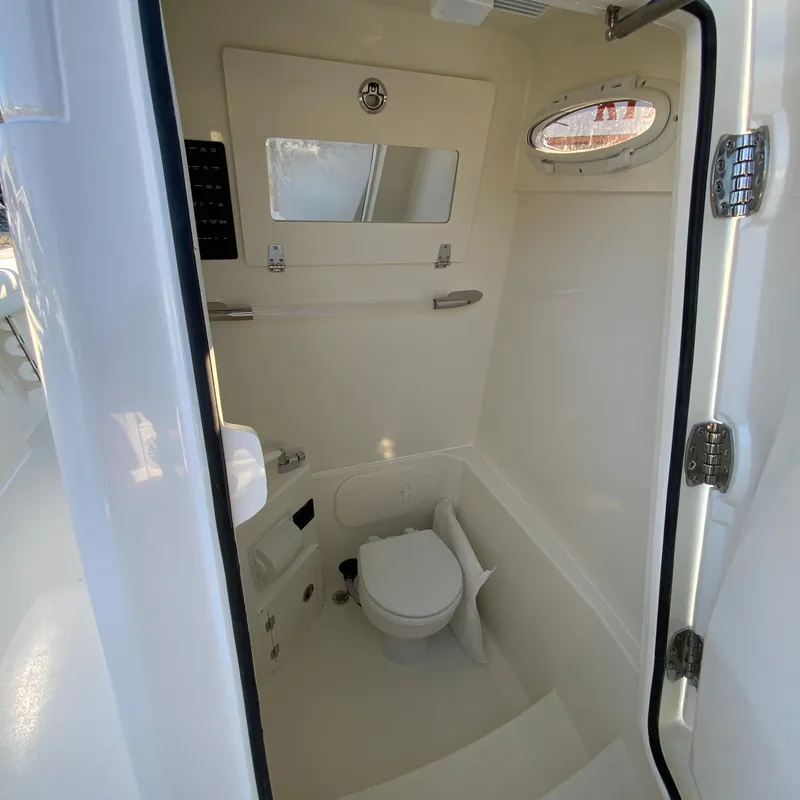 Slide: The Image of 2025 Cobia 240 Center Console boat interior bathroom with toilet and mirror. - 30