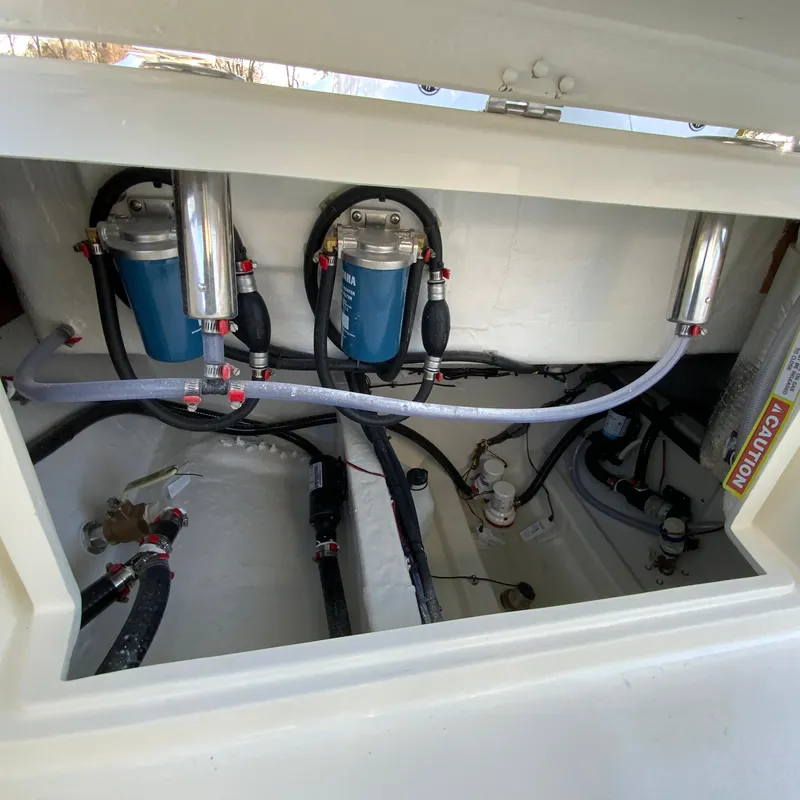 Slide: The Image of 2025 Cobia 240 Center Console boat engine compartment with fuel filters and hoses. - 35