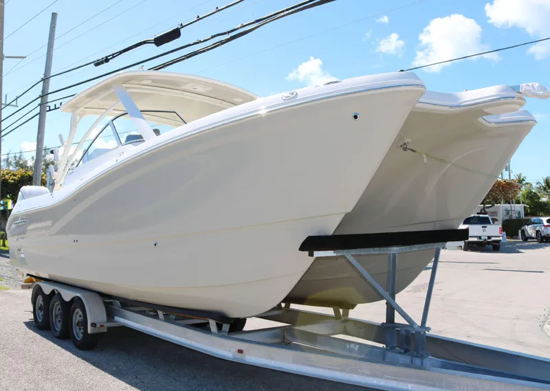 Slide: The Image of 2025 World Cat 296DC boat on trailer under clear sky. - 2