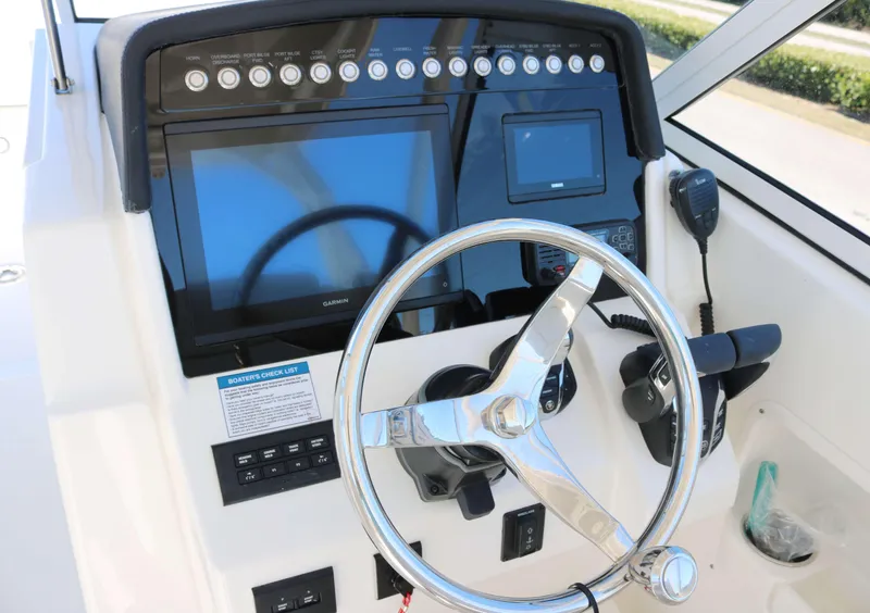 Slide: The Image of 2025 World Cat 296DC boat dashboard with steering wheel and navigation controls. - 6