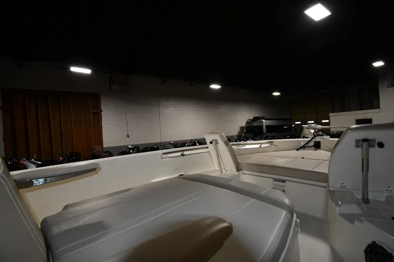 Slide: The Image of 2022 Boston Whaler 250 Dauntless interior view in a dimly lit showroom. - 34