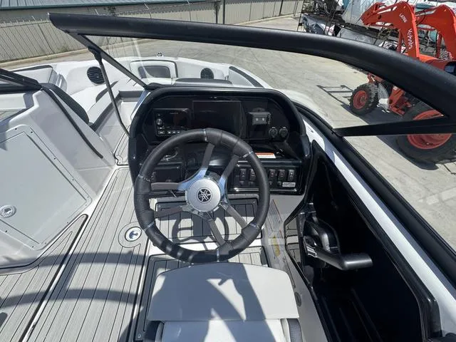 Slide: The Image of 2025 Yamaha Boats 195 S docked by a lakeside restaurant with people dining. - 5