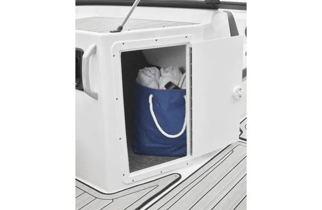 Slide: The Image of 2024 Yamaha Boats 195S storage compartment with blue bag on deck. - 12