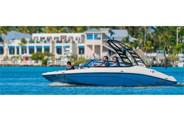 Slide: The Image of 2024 Yamaha Boats 195S cruising on a sunny day near waterfront buildings. - 7