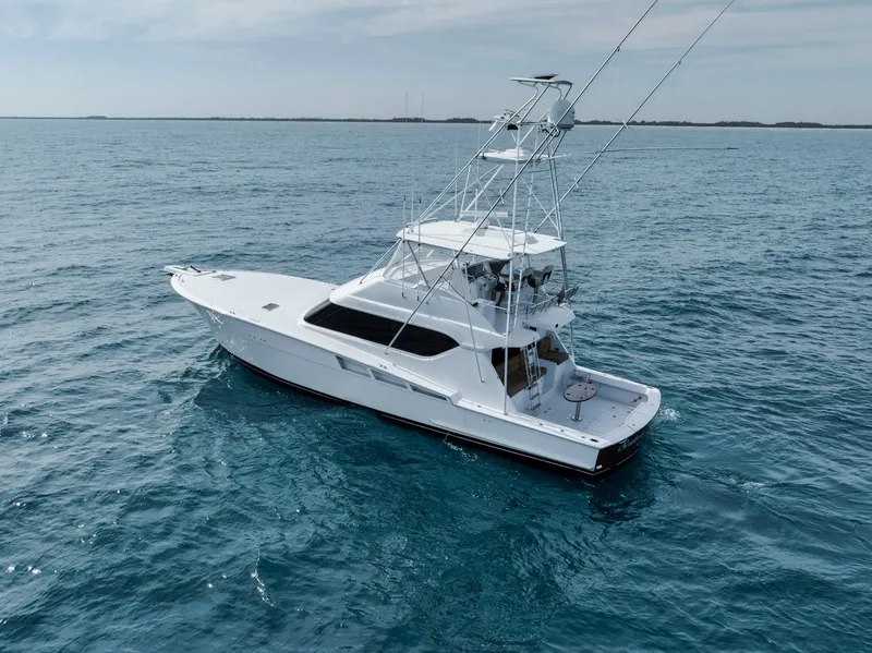 Slide: The Image of 1999 Hatteras 60 Convertible yacht cruising on open blue waters. - 14