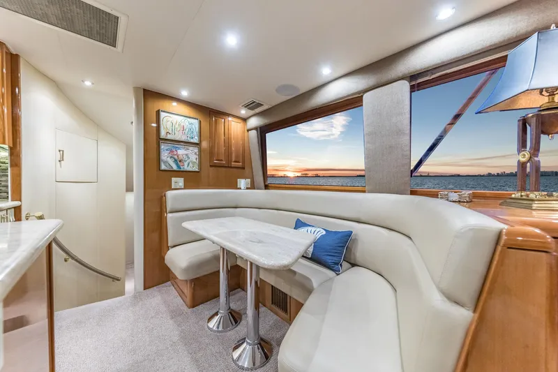 Slide: The Image of Interior of 1999 Hatteras 60 Convertible yacht with elegant dining area and scenic window view. - 26