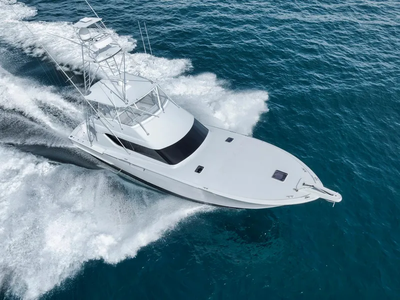 Slide: The Image of 1999 Hatteras 60 Convertible yacht cruising on open water, aerial view. - 3