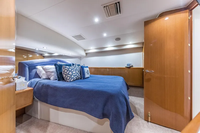 Slide: The Image of Luxurious bedroom interior of 1999 Hatteras 60 Convertible yacht with blue bedding. - 31