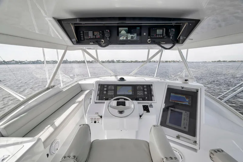 Slide: The Image of 1999 Hatteras 60 Convertible yacht helm with advanced navigation systems on open water. - 40