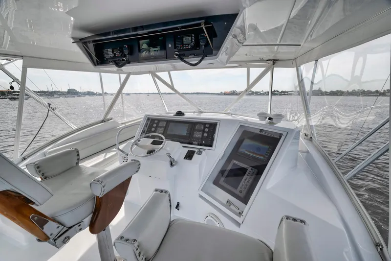 Slide: The Image of 1999 Hatteras 60 Convertible yacht helm with modern navigation equipment and panoramic water view. - 41