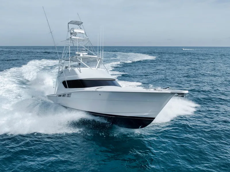 Slide: The Image of Hatteras 60 Convertible 1999 yacht cruising swiftly on open ocean waters. - 7