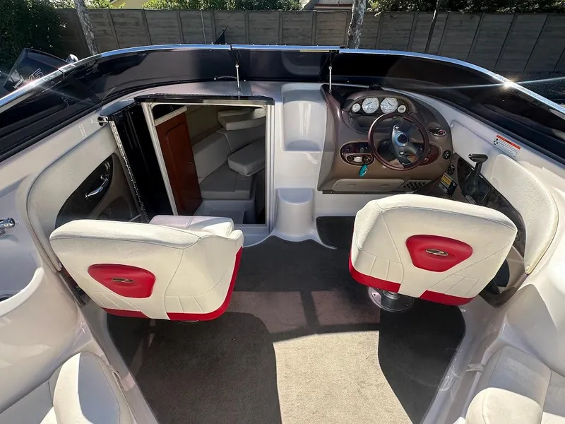 Slide: The Image of Interior of a 2006 Regal 2450 Cuddy boat with white and red seating. - 16