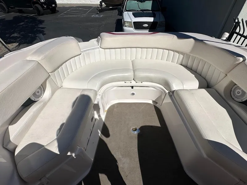 Slide: The Image of 2006 Regal 2450 Cuddy boat interior with white cushioned seating and carpeted floor. - 17
