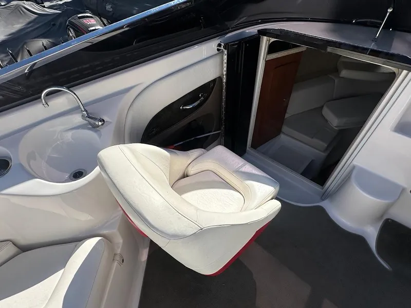 Slide: The Image of 2006 Regal 2450 Cuddy interior with white seating, sink, and cabin entrance. - 18