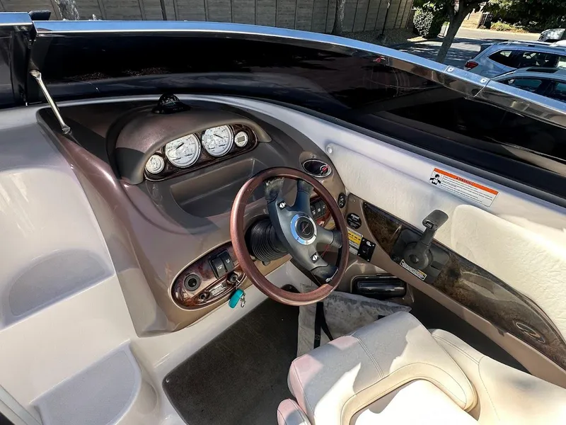 Slide: The Image of 2006 Regal 2450 Cuddy boat interior with steering wheel and dashboard controls. - 21