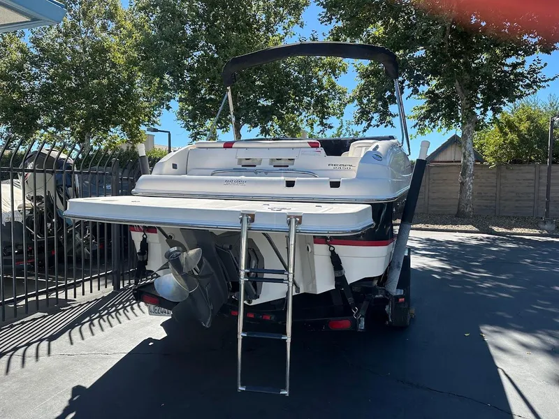 Slide: The Image of 2006 Regal 2450 Cuddy boat, rear view with ladder, parked outdoors. - 9