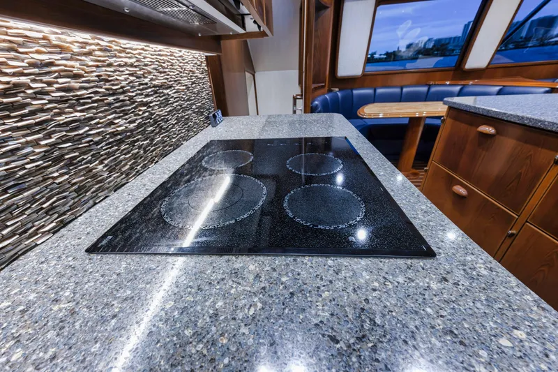 Slide: The Image of Modern kitchen in 2015 Viking 70 Convertible yacht with sleek cooktop and stone backsplash. - 40