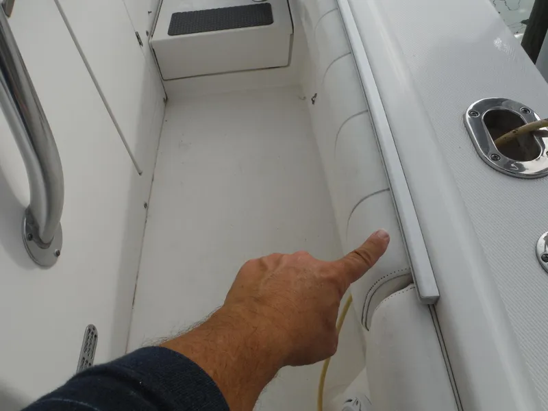 Slide: The Image of 2012 Regulator 32 Forward Seating boat interior with hand pointing at seating area. - 45
