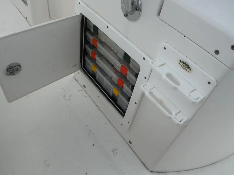Slide: The Image of 2012 Regulator 32 Forward Seating boat storage compartment with organized tackle boxes. - 47