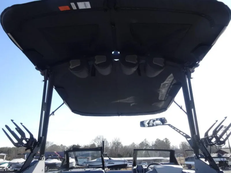Slide: The Image of 2025 Axis T250 boat with a black canopy and wakeboard racks, viewed from the rear. - 5