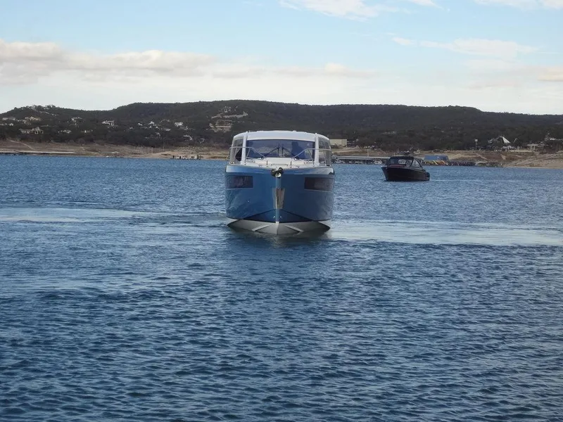 Slide: The Image of 2025 Jeanneau DB/43 OB boat on calm water, distant hills in background. - 16