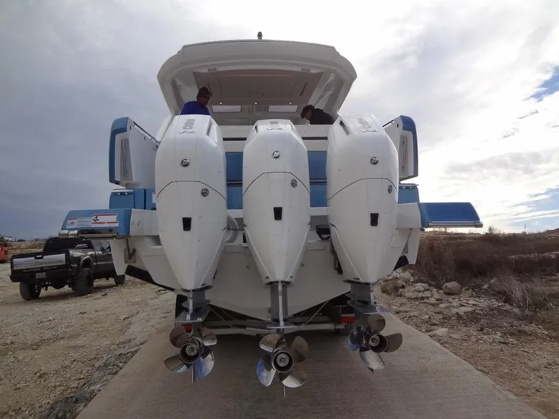 Slide: The Image of 2025 Jeanneau DB/43 OB boat with triple outboard engines, rear view on a trailer. - 22
