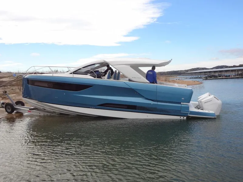 Slide: The Image of 2025 Jeanneau DB/43 OB boat in water, sleek design, blue hull, outboard engines. - 26
