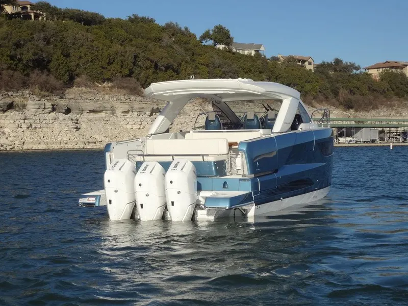 Slide: The Image of 2025 Jeanneau DB/43 OB boat with triple outboard engines on a scenic lake. - 34