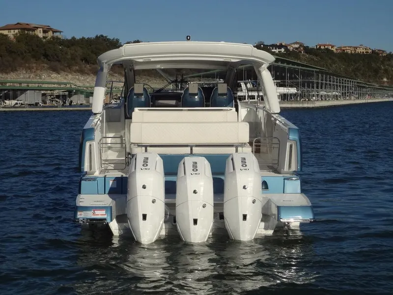 Slide: The Image of 2025 Jeanneau DB/43 OB boat with triple outboard engines on a calm lake. - 35