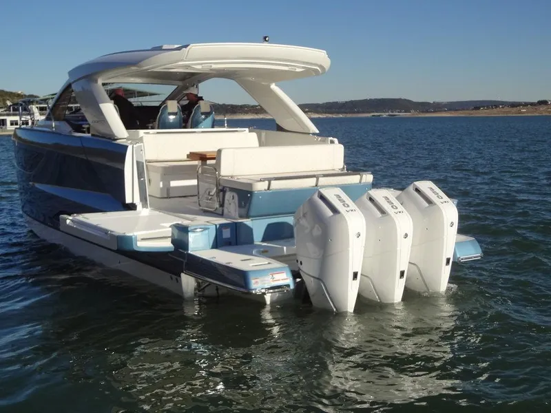 Slide: The Image of 2025 Jeanneau DB/43 OB boat with triple outboard engines on a calm lake. - 37
