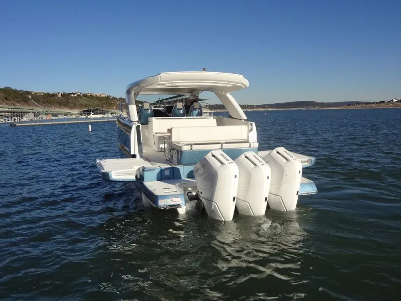 Slide: The Image of 2025 Jeanneau DB/43 OB boat with triple outboard engines on a calm lake. - 39