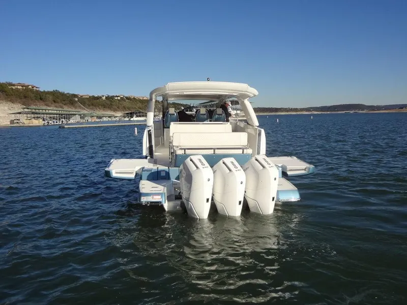 Slide: The Image of 2025 Jeanneau DB/43 OB boat with triple outboard engines on a calm lake. - 40