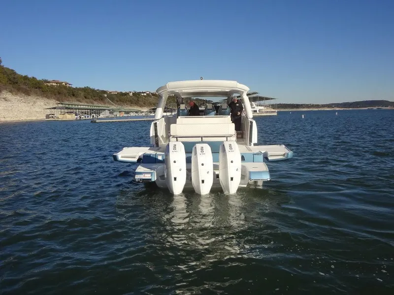 Slide: The Image of 2025 Jeanneau DB/43 OB boat on water, rear view with multiple outboard engines. - 41