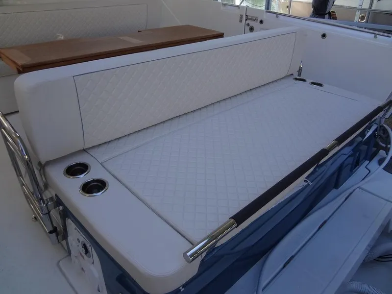 Slide: The Image of 2025 Jeanneau DB/43 OB boat interior with cushioned seating and cup holders. - 49