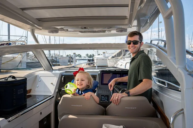 Slide: The Image of Father and child enjoying a 2025 Nimbus Weekender 9 boat at the marina. - 15