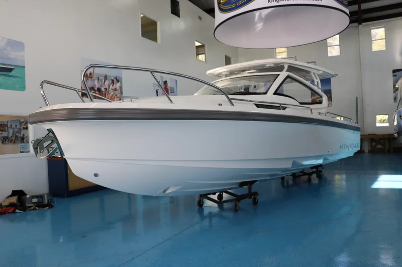 Slide: The Image of 2025 Nimbus Weekender 9 boat displayed indoors on a blue floor. - 2