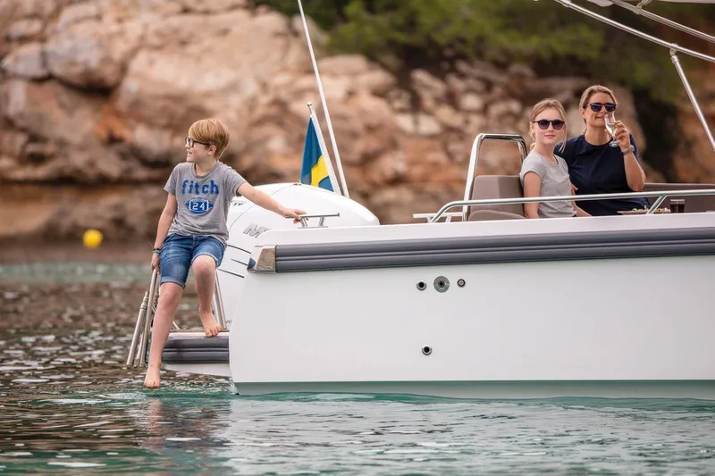 Slide: The Image of Family enjoying a day on a 2025 Nimbus Weekender 9 boat in scenic waters. - 22