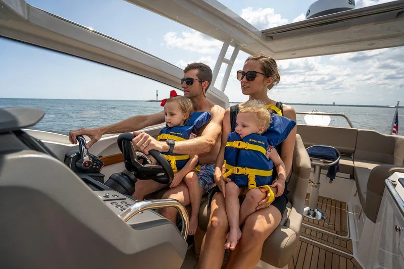 Slide: The Image of Family enjoying a ride on a 2025 Nimbus Weekender 9 boat, wearing life jackets. - 26