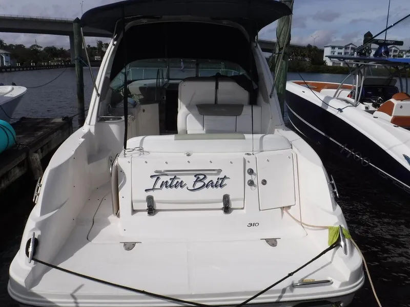 Slide: The Image of 2007 Sea Ray 310 boat docked, rear view with "Inter Bait" name visible. - 2