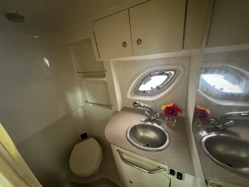 Slide: The Image of 2007 Sea Ray 310 boat bathroom with sink, toilet, and porthole window. - 21