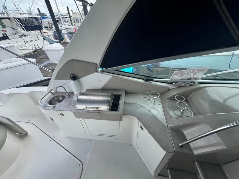 Slide: The Image of 2007 Sea Ray 310 boat interior with kitchenette and cup holders, docked at marina. - 22