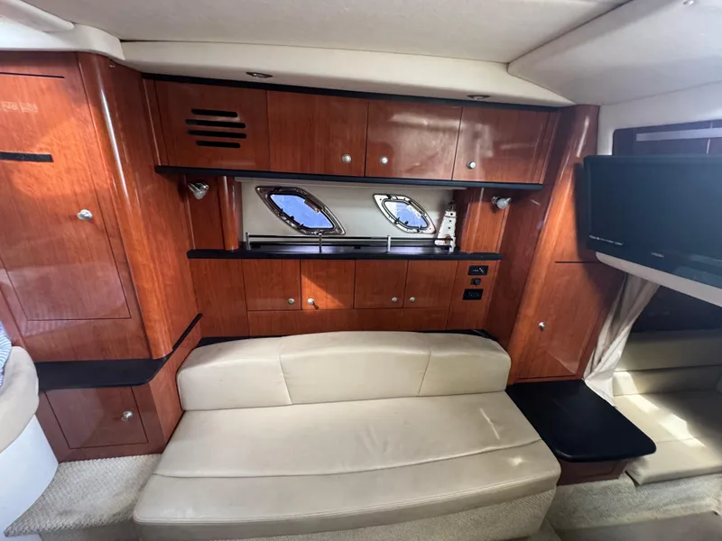 Slide: The Image of Luxurious 2007 Sea Ray 310 cabin interior with wood cabinetry and beige seating. - 23