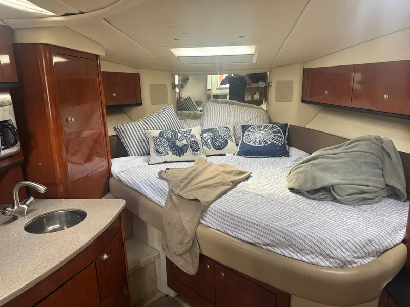 Slide: The Image of Luxurious 2007 Sea Ray 310 cabin interior with bed, sink, and wooden cabinetry. - 25