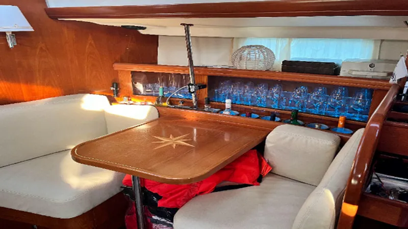 Slide: The Image of Interior of 2005 Beneteau 57 yacht with wooden table and cushioned seating. - 4