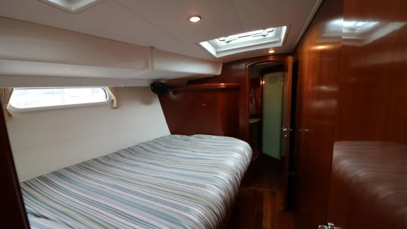 Slide: The Image of Luxurious cabin interior of a 2005 Beneteau 57 yacht with striped bedding. - 7