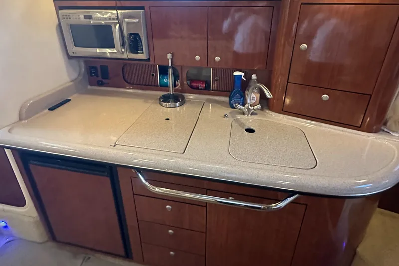 Slide: The Image of 2008 Sea Ray 340 Sundancer kitchen with microwave, sink, and wooden cabinetry. - 15